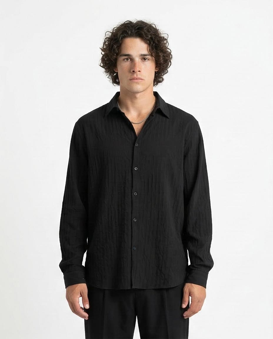 Man wearing a black button-up shirt against a white background