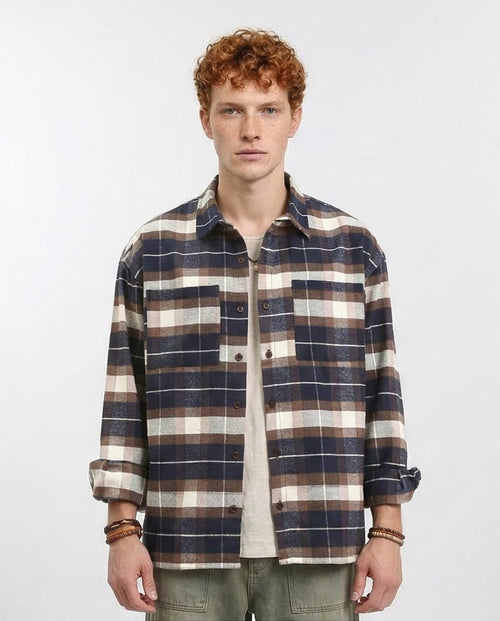 Man wearing a plaid shirt on a plain background