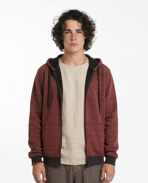 Man wearing a red hoodie over a beige shirt on a white background