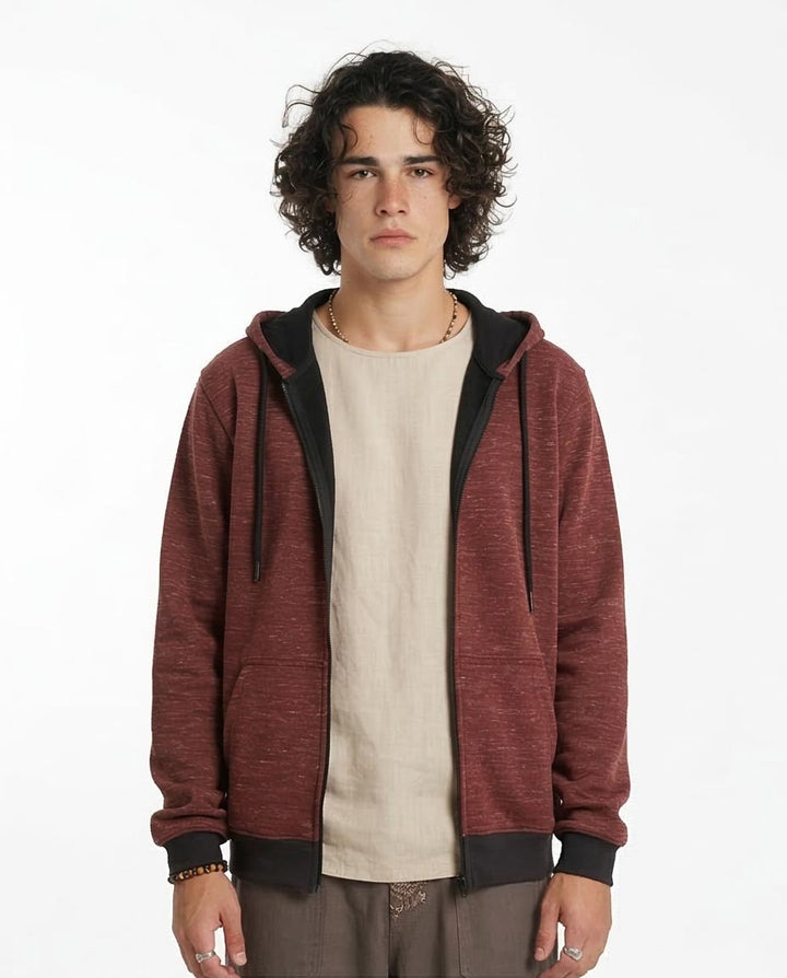 Man wearing a red hoodie over a beige shirt on a white background