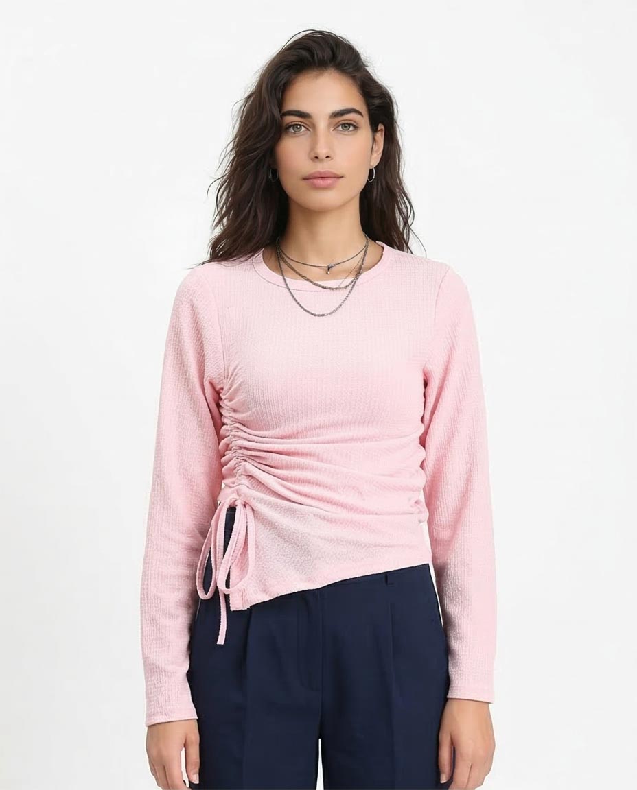 Woman wearing a pink long-sleeve top with a tie detail on a white background
