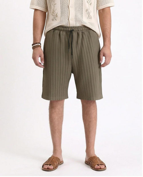 Man wearing olive green shorts on a white background