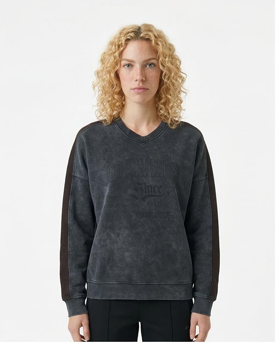 Woman wearing a dark gray sweatshirt with text on a white background