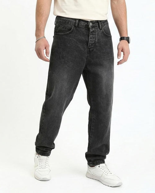 Person wearing black jeans and white sneakers on a white background