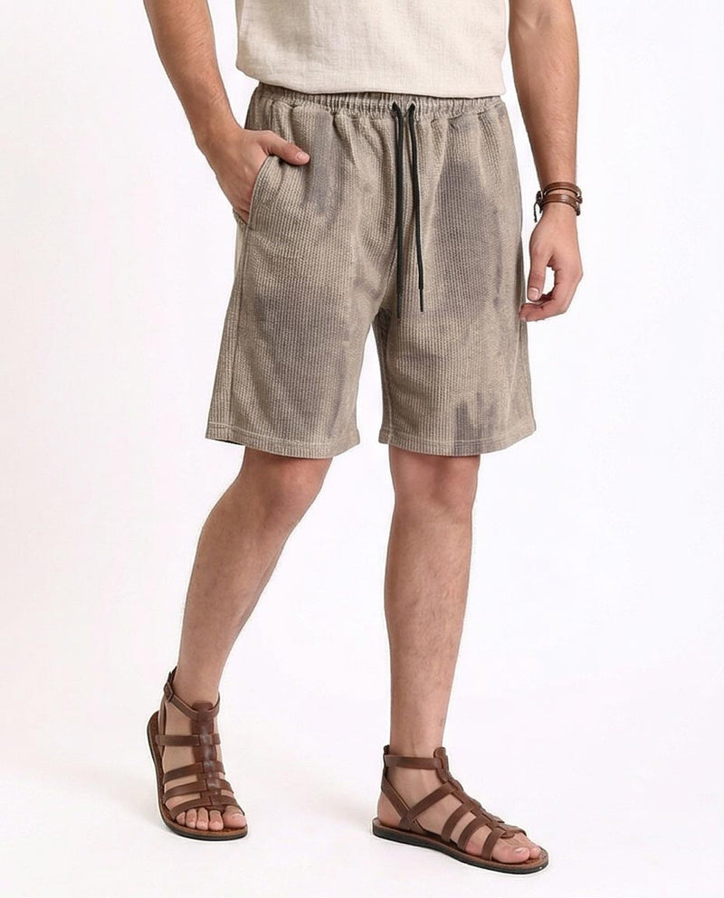 Person wearing beige shorts and sandals on a white background