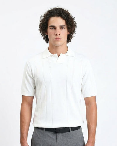 Man wearing a white short-sleeve shirt and gray pants on a light gray background