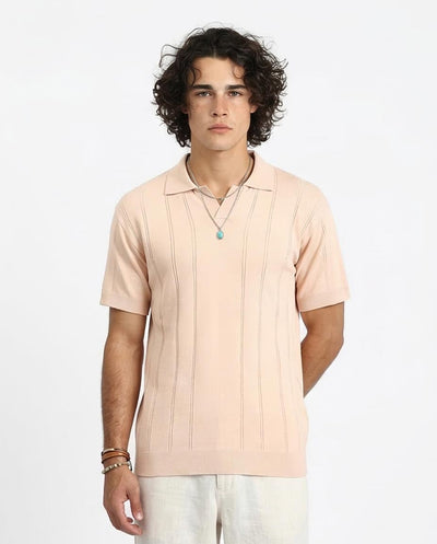 Man wearing a light pink polo shirt on a white background