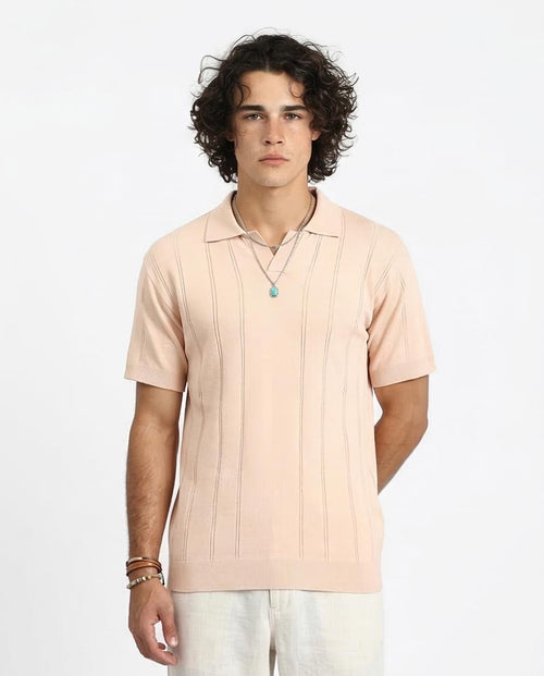 Man wearing a light pink polo shirt on a white background