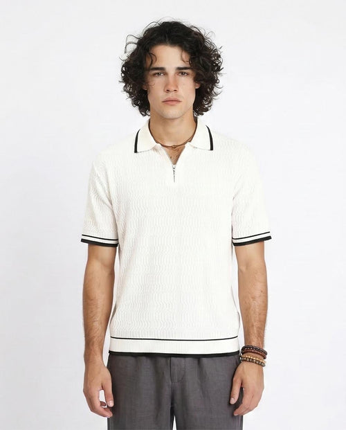 Man wearing a white polo shirt with black trim on a plain background