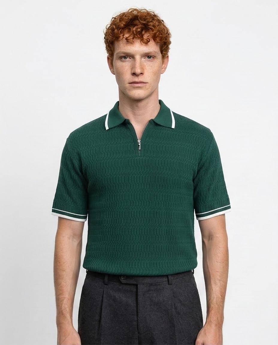 Man wearing a green knitted polo shirt with white trim on a light gray background