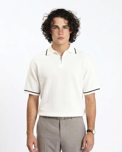 Man wearing a white polo shirt with black trim on a plain background