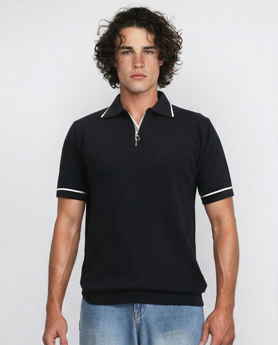 Man wearing a black polo shirt with white trim on a plain background