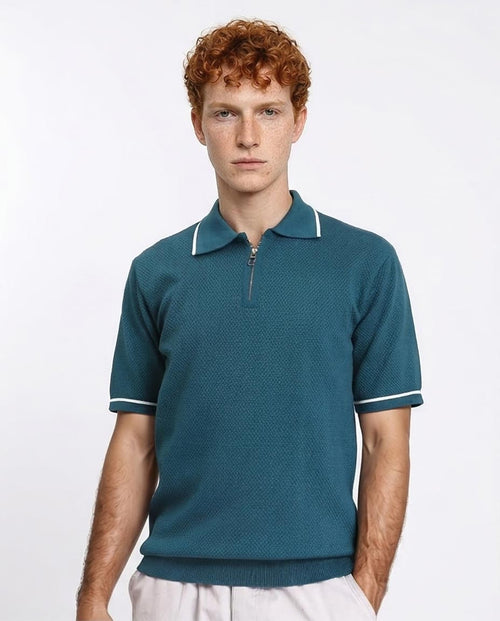 Man wearing a teal polo shirt with white trim on a plain background