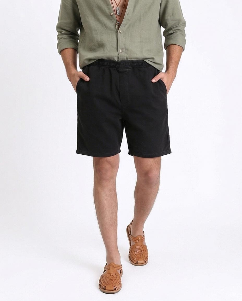 Man wearing a green shirt and black shorts on a white background