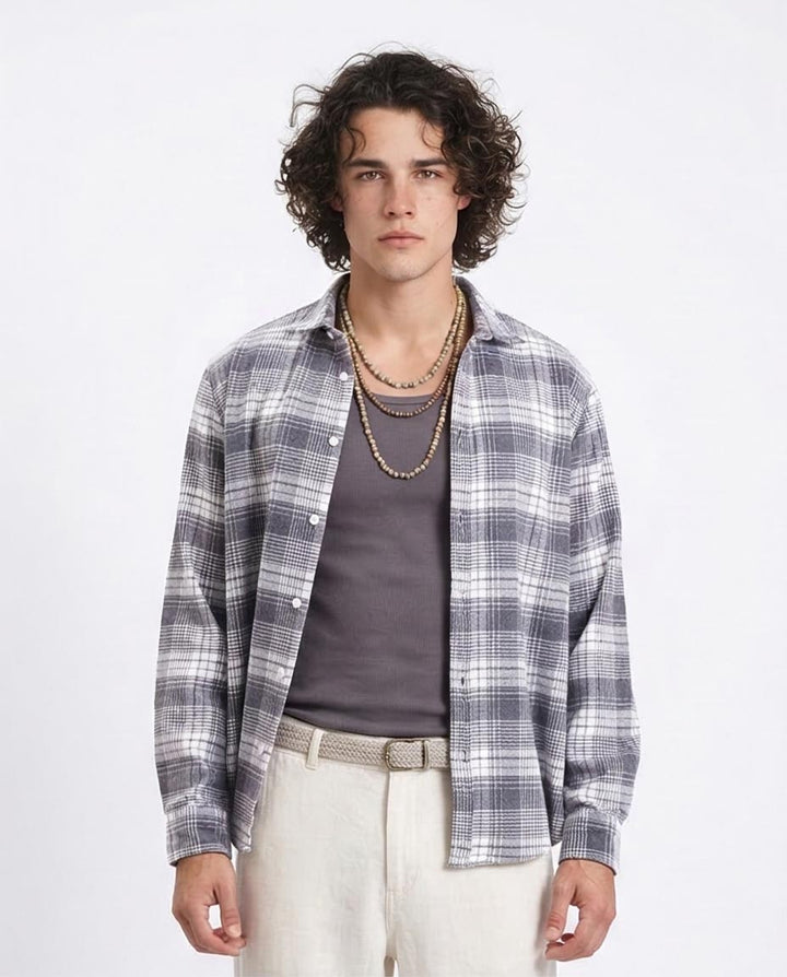 Man wearing a plaid shirt over a gray t-shirt with a white background