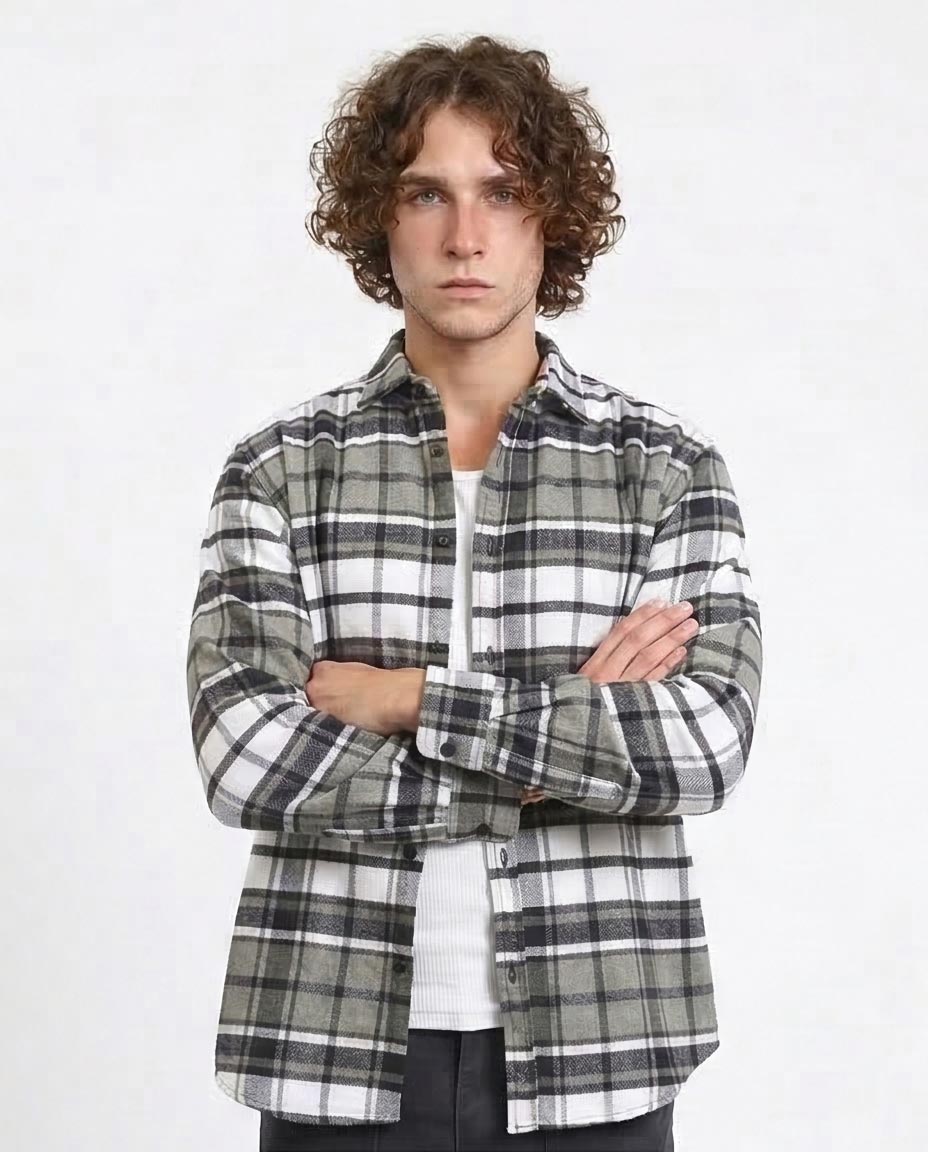 Man wearing a plaid shirt with arms crossed on a white background