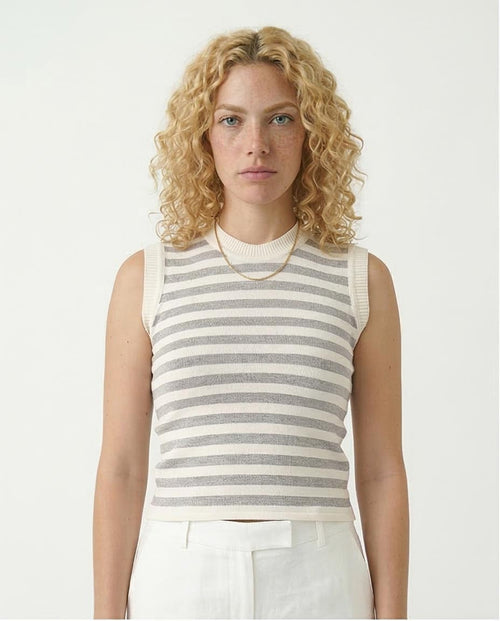Woman wearing a striped sleeveless top against a plain background