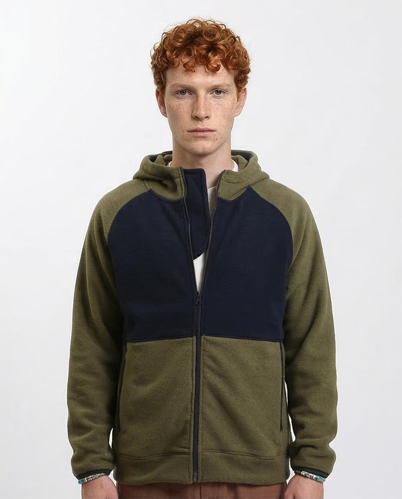 Man wearing a green and navy color-blocked hoodie on a white background
