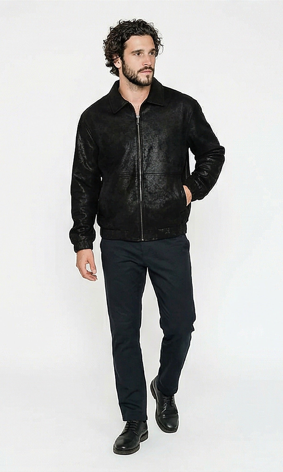 Man wearing a black leather jacket and pants on a white background