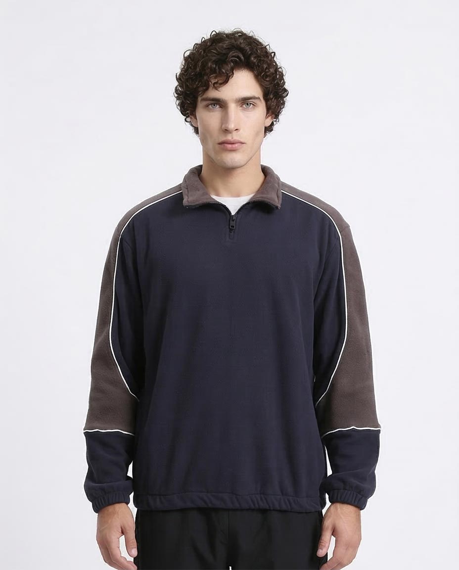 Man wearing a navy and brown long-sleeve shirt with a white background