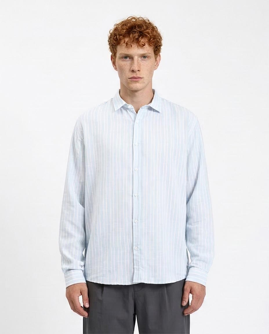 Man wearing a light blue striped shirt against a white background