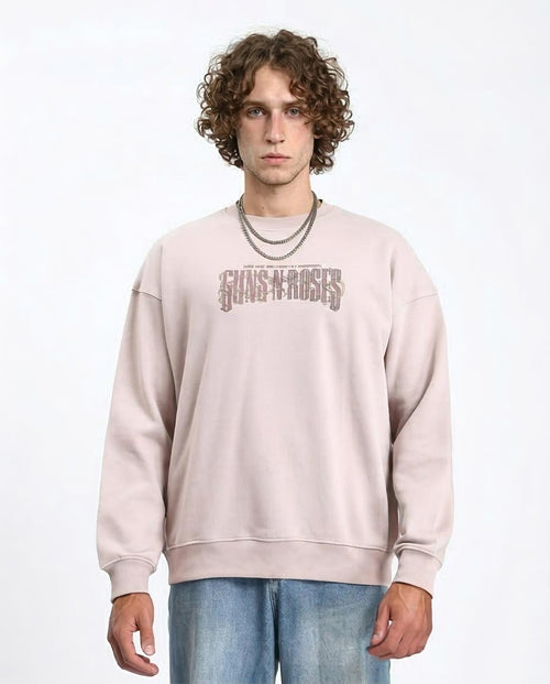 Person wearing a beige 'Guns N' Roses' sweatshirt on a white background
