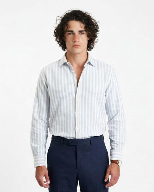 Man wearing a white striped shirt and navy pants on a white background