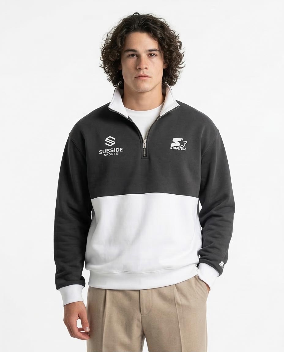 Man wearing a black and white pullover with logos on a white background