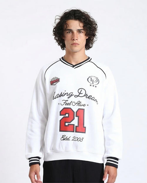 Person wearing a white sweatshirt with text and numbers on a plain background