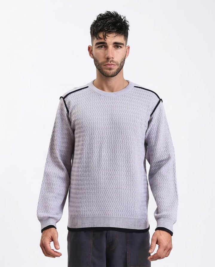 Man wearing a light gray sweater with black accents on a white background