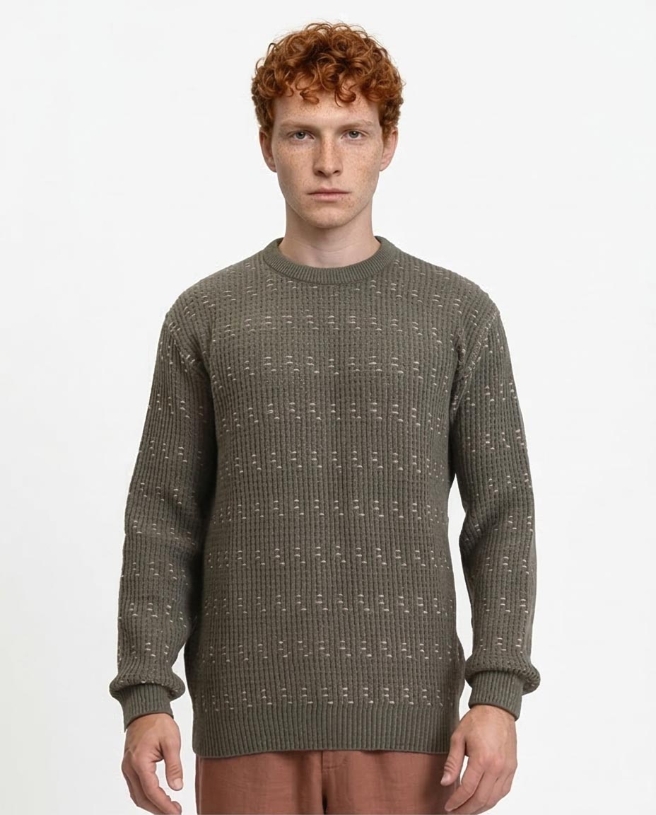 Man wearing a green patterned sweater on a white background