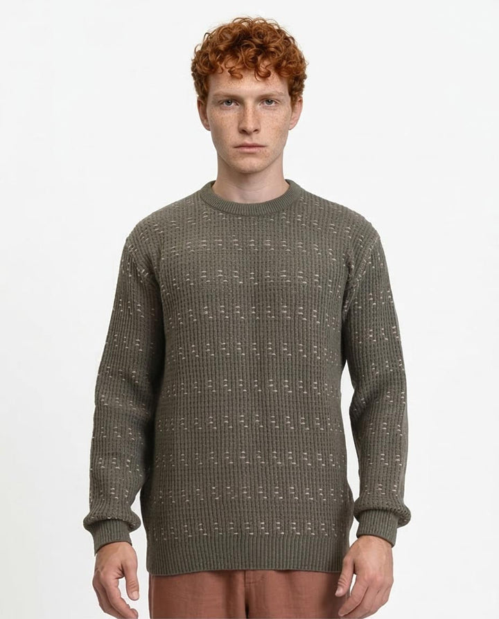 Man wearing a green patterned sweater on a white background