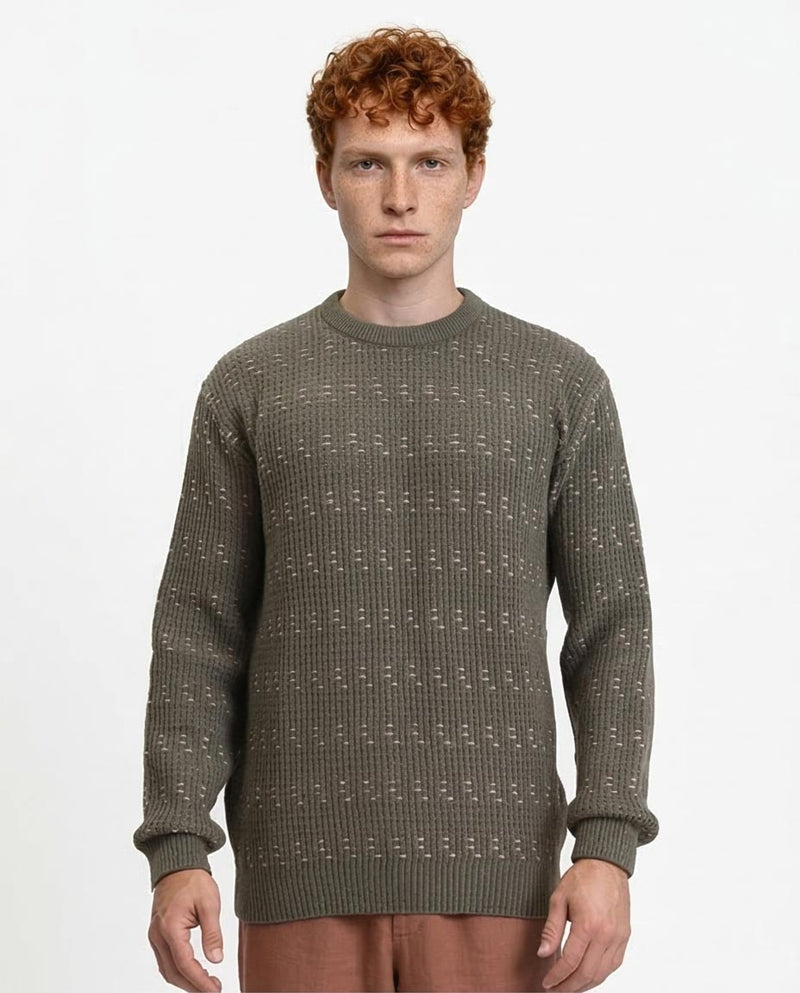 Man wearing a green patterned sweater on a white background