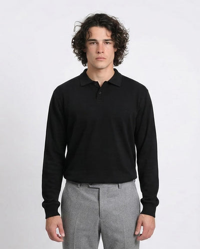 Man wearing a black long-sleeve polo shirt and gray pants on a white background