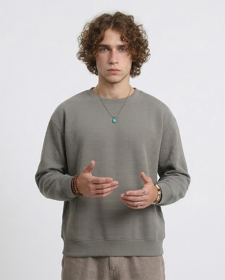 Man wearing a gray sweater on a white background