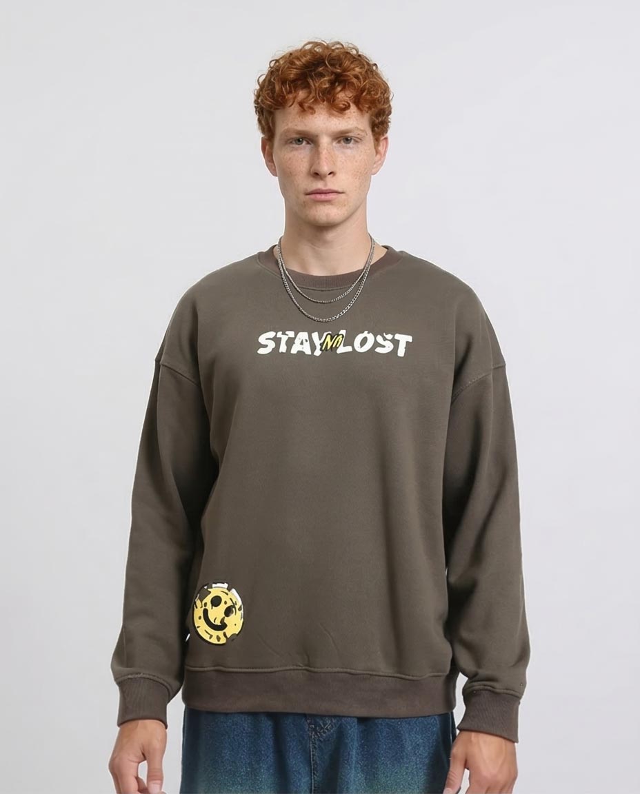 Person wearing a brown sweatshirt with 'STAY LOST' text on a plain background