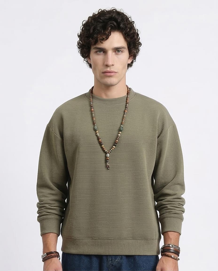 Man wearing a green sweater with a plain background