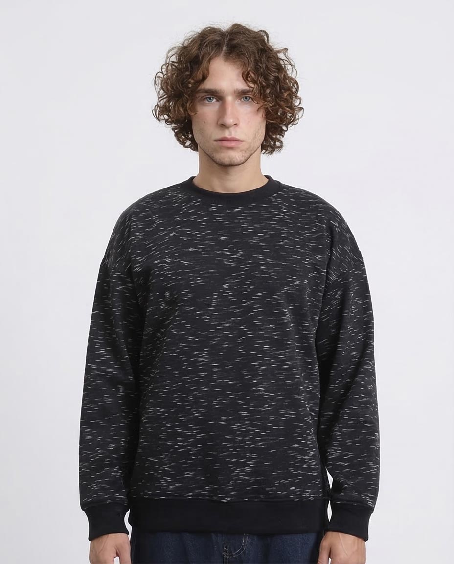 Man wearing a black patterned sweatshirt against a white background
