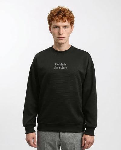 Man wearing a black sweatshirt with text on a white background