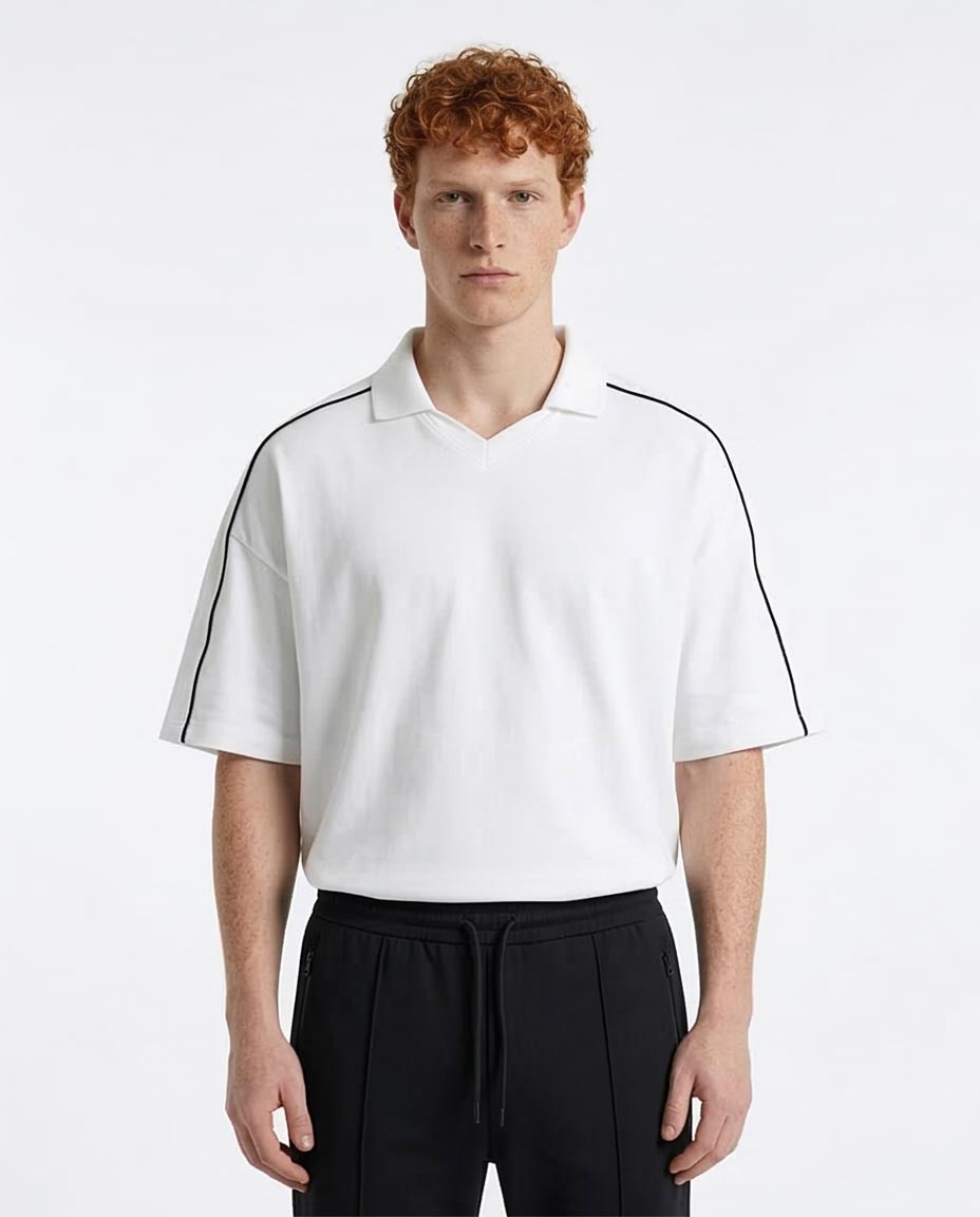 Man wearing a white polo shirt with black accents on a white background