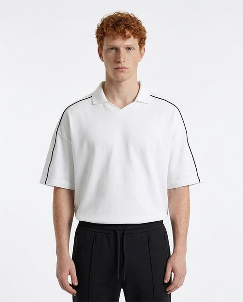 Man wearing a white polo shirt with black accents on a white background