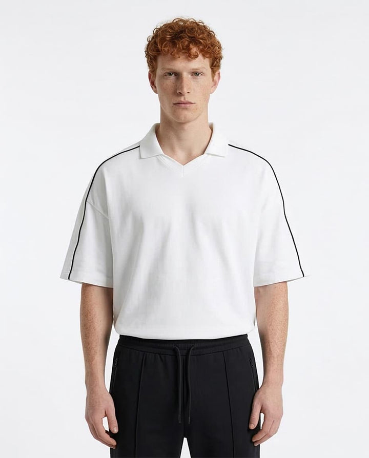 Man wearing a white polo shirt with black accents on a white background