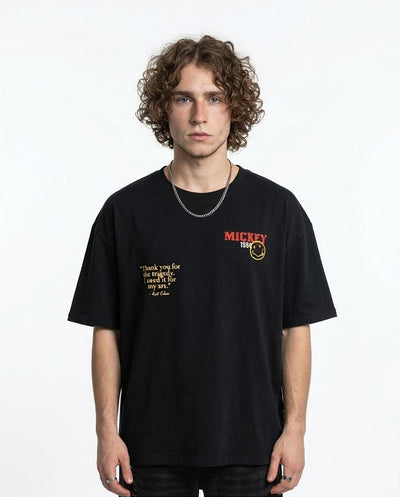 Person wearing a black t-shirt with text and logo on a white background