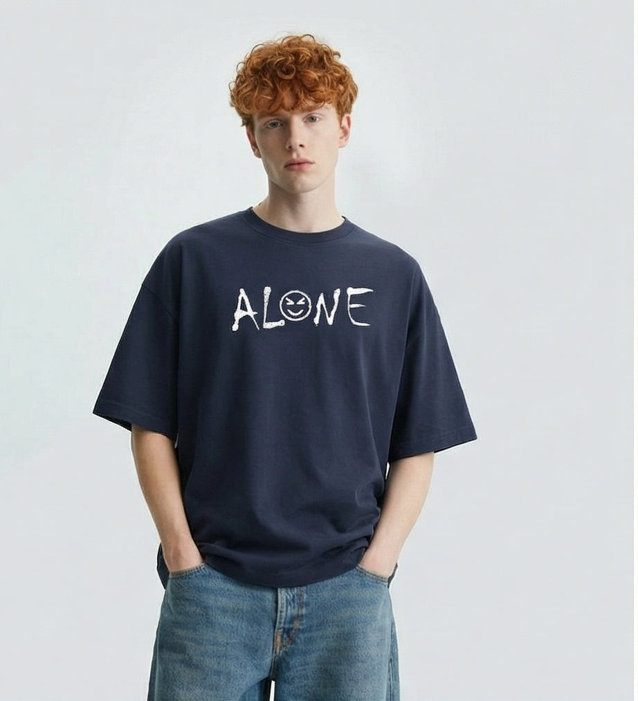 Man wearing a navy blue t-shirt with 'ALONE' printed on it against a plain background