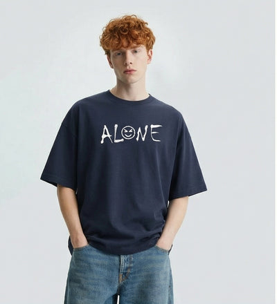 Man wearing a navy blue t-shirt with 'ALONE' printed on it against a plain background