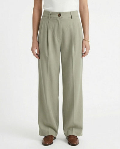 Woman wearing light green wide-leg pants on a white background