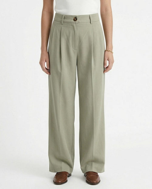 Woman wearing light green wide-leg pants on a white background