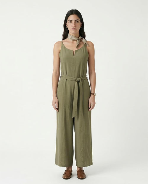 Woman wearing an olive green jumpsuit on a white background