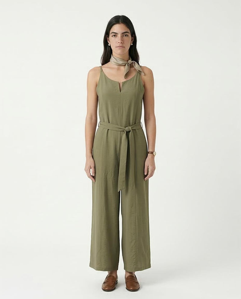 Woman wearing an olive green jumpsuit on a white background