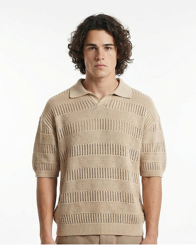 Man wearing a beige patterned sweater against a white background